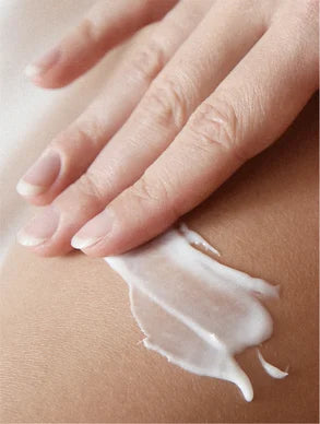 Creme natural corpo pele sensível sendo aplicado suavemente na pele por uma mão delicada